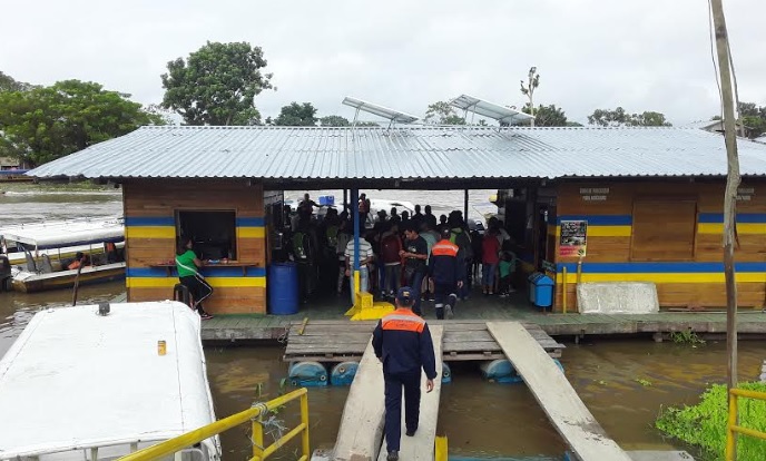 Personas en una casa sobre el agua en el puerto de Leticia