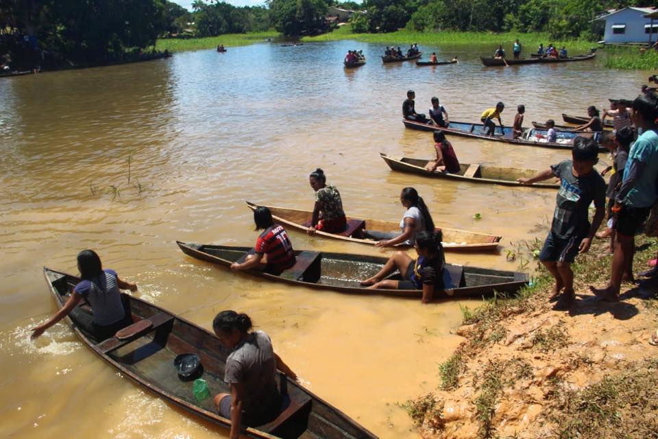 Pessoas em canoa no dia indio