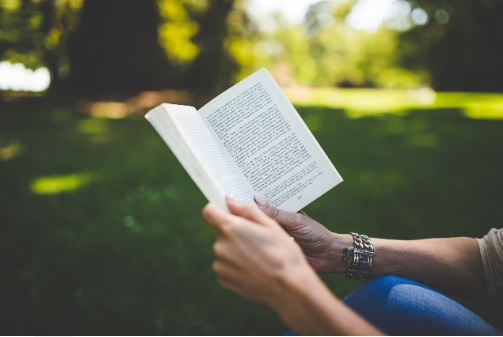 Persona sosteniendo y leyendo un libro