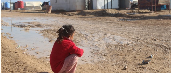 Niña sentada mirando una casa