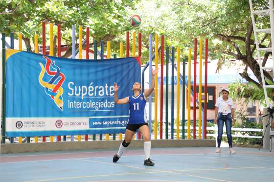 Mujer haciendo un saque en partido de voleibol