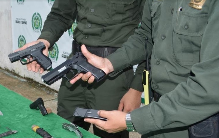 Dos policias sosteniendo cada uno un arma