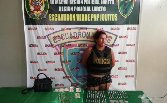 Mujer al lado de material narcotico incautado 