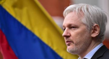 Julian Assange al lado de una bandera de Ecuador