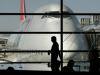 Persona pasando por una ventana en un aeropuerto al lado de avion