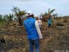 Personas caminando por una zona consumida por un incendio ya controlado