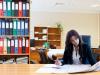 Mujer en un escritorio leyendo un periodico